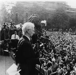 Person(s) in Photograph: Bertrand Russell, unidentified people Description: Bertrand Russell addressing a rally organized by the Campaign for Nuclear Disarmament in Trafalgar Square on September 20, 1959. Russell had played a leading role in the establishment of this anti-nuclear pressure group early the previous year and remained its President until resigning in October 1960 over disagreements about tactics with others in the organization's leadership. Archive Box Number: RA3 Rec. Acq. 1327 Date: 1959